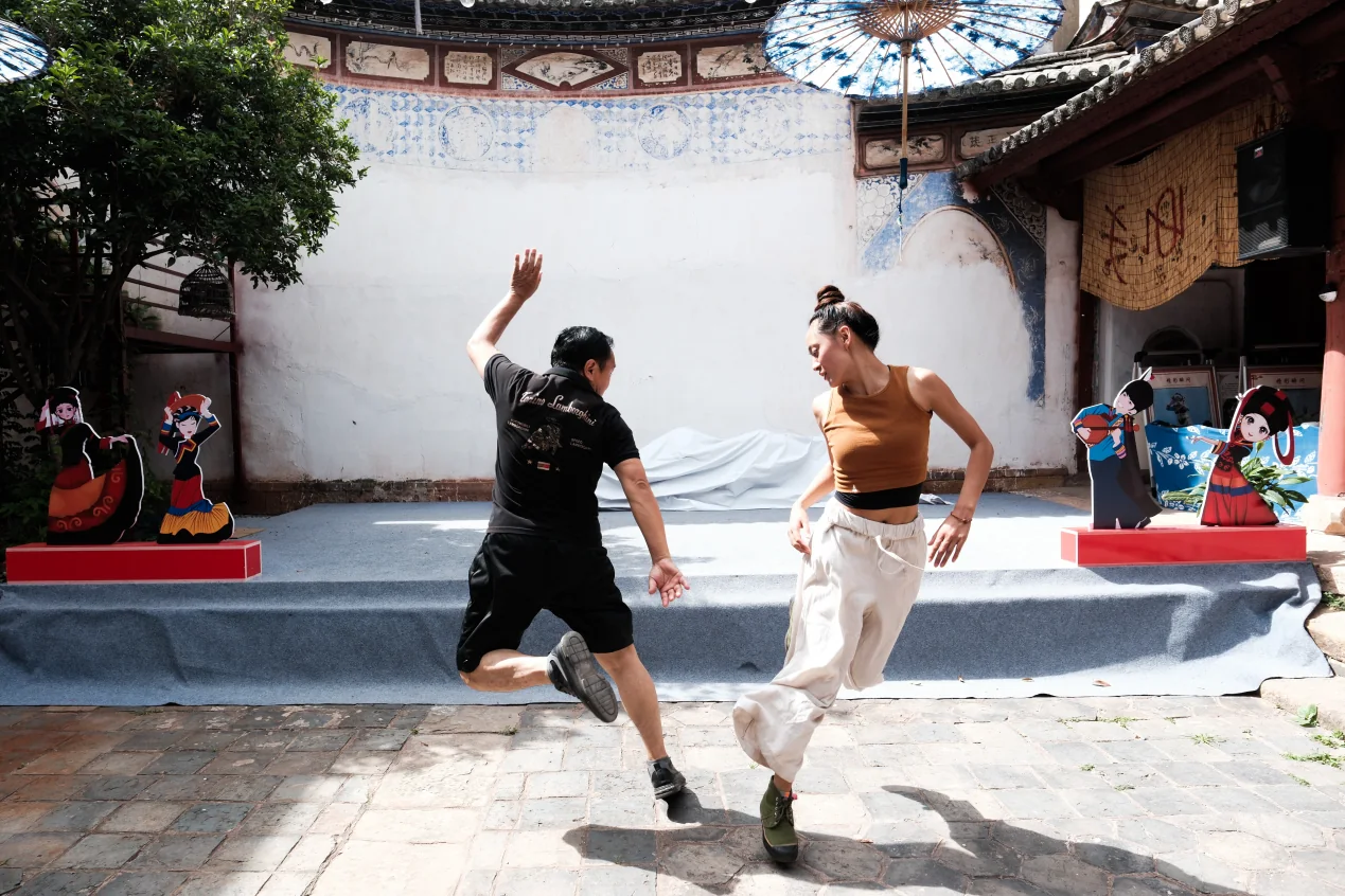 两位舞者在院落中相对跳跃