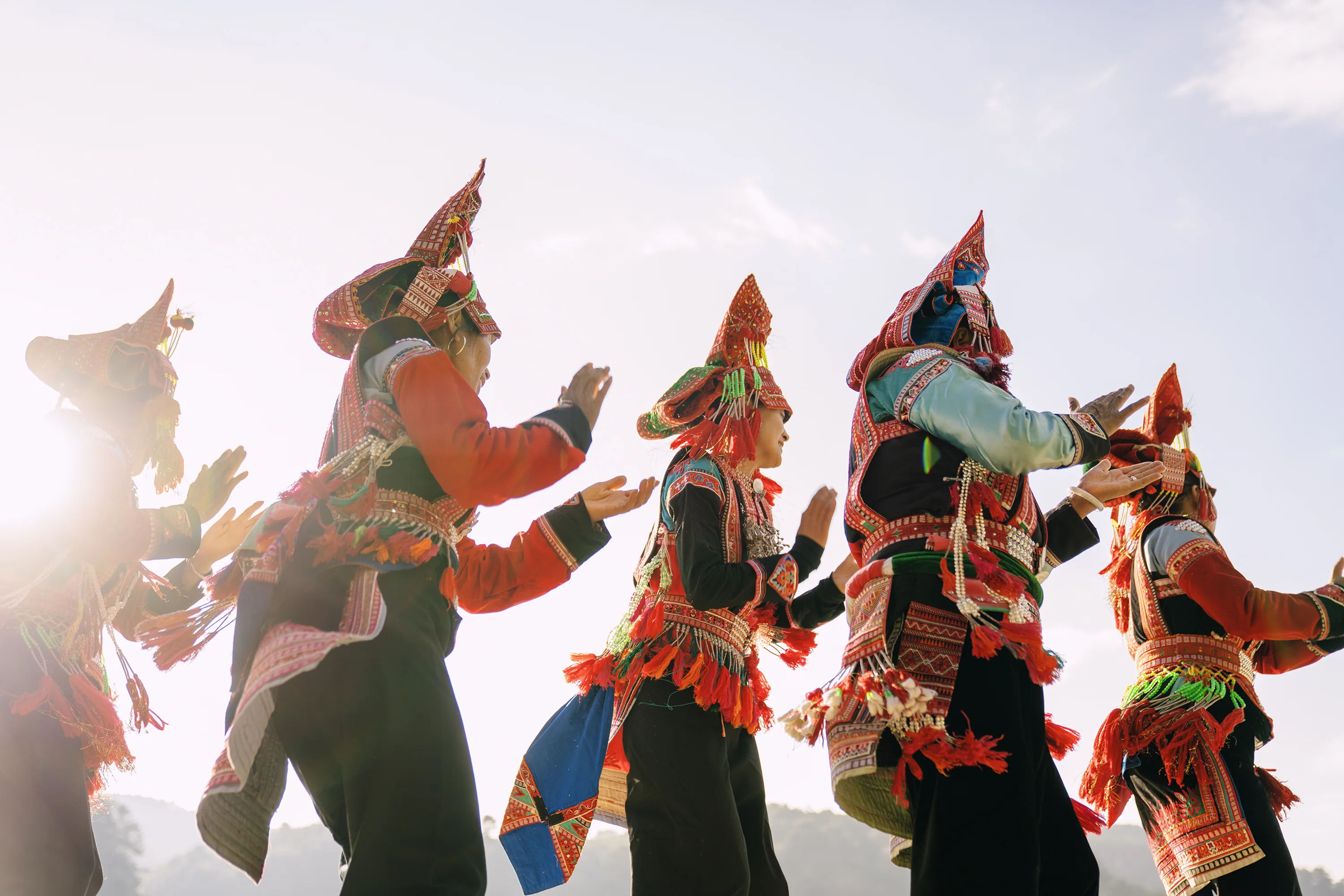 People in colorful dress dancing in backlight